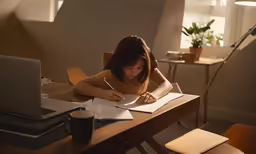 a woman taking notes in her notepad and writing in a notebook