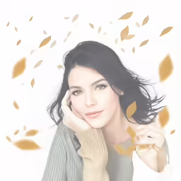 a woman poses on a white surface with autumn leaves all over her
