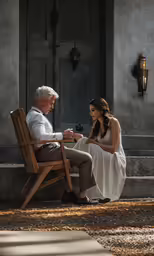 a man and woman are sitting on chairs with a cat