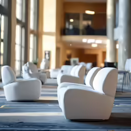 a room with white chairs and windows inside of it