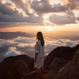 woman standing on a mountain top looking at the sky