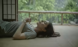 woman lying on the ground smiling and waving her hands