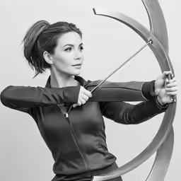 a beautiful woman holding an arrow next to a large object