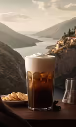 beverage on table overlooking a mountainous valley with mountains and clouds
