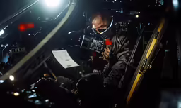 an airplane fighter reading something out in the dark