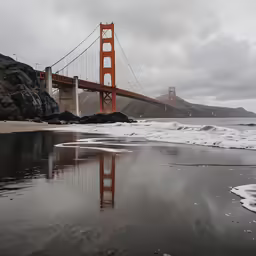 a bridge over water near some rocks and a hill