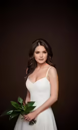 a woman is holding a bouquet with green flowers