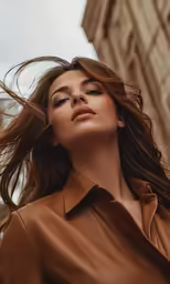 woman in brown leather coat and blouse posing