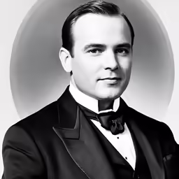 a man in a tuxedo posing for a black and white portrait