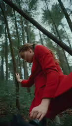 a woman is walking in a forest with the light on