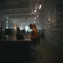 woman in an office typing on a black vintage typewriter