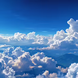 white clouds over mountains in a blue sky,the sky is full of cloud cover and mountains in the background