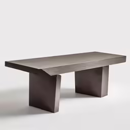 an elegantly shaped bench is made from cement