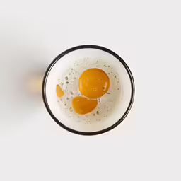a cup with liquid inside is full of eggs