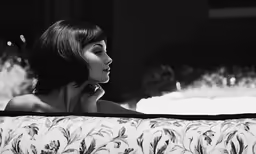 woman sitting on a couch in black and white photo