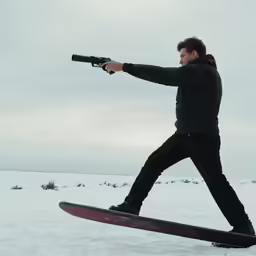 a man wearing a black jacket aims a gun