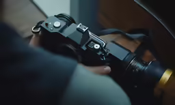 a person holding a camera near a window