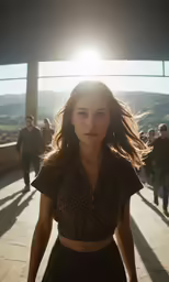 a beautiful woman standing near the sun with other people walking behind her