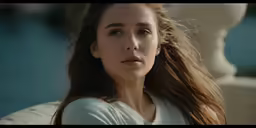 a woman with long hair staring into the distance