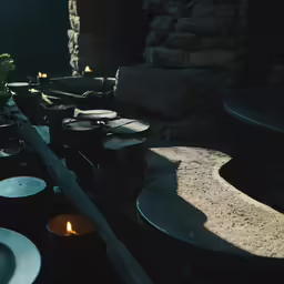 black plates sitting on the counter with a glowing candle