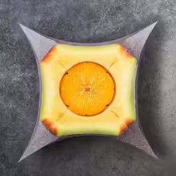 orange in square shaped object on grey surface