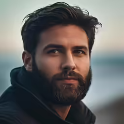 a man with a beard wearing a black jacket