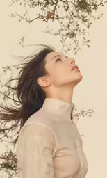 a woman standing with her hair blowing in the wind