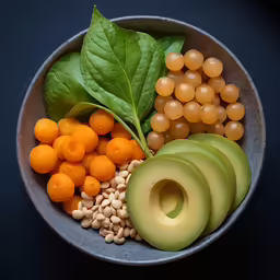 this bowl has many fruits, seeds, avocado and other foods