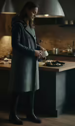 a young woman in a long coat is holding a mug