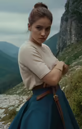 the woman is standing on the side of the hill