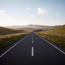 a road leading into the mountains at sunset