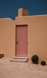 a desert style doorway with pink door in front of a wall