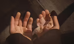 a person with gloves on holding their hands