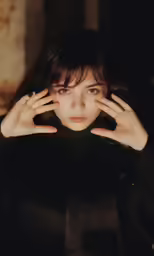 a close up image of a person holding their hands on their face