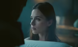 a woman staring at someone in the dark