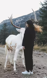a man who is standing next to a white and brown reindeer