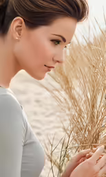a woman standing next to a tall grass field