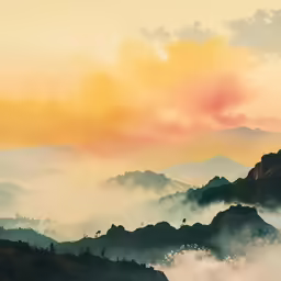 the sky is shown above the hills and fog