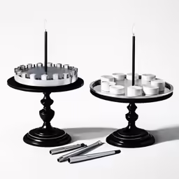 two candle stands with candles on each one, one lit up