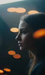 woman gazing out window at night light