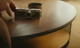 a person holding an old camera with their thumb on it