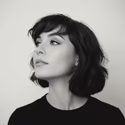 a black and white photo of a woman looking over her shoulder