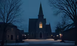 an old church building at night, lit by street lights