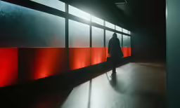 a person walking down a corridor in the dark