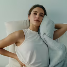 the woman is laying down with her head near her elbow
