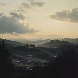 a view over the valley at sunset with trees and buildings