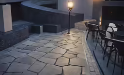 an empty outdoor seating area lit up with a lamp