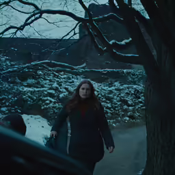 a woman walks down the snowy road with her coat on