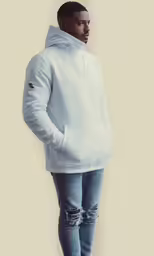 a male model in a white sweatshirt and ripped jeans