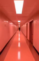 a man is walking down an empty hallway